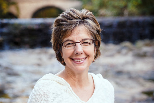 Rita Cevasco wearing white sweater standing in front of riverbed