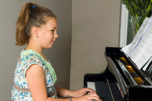 Girl playing a piano with music book open